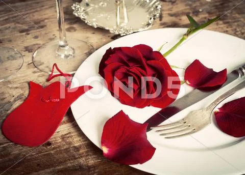 Table setting with red roses on plate - celebrating Valentine's Stock Photos