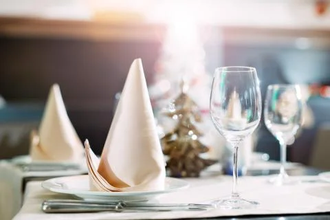 Table setting in the restaurant. Christmas tree on the background. Stock Photos
