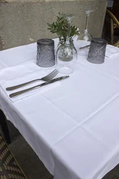 Table setting in a restaurant with glasses and plates on a white tablecloth 스톡 사진