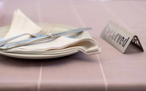 Table setting in a restaurant with reserved card. Stock Photos