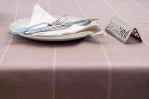 Table setting in a restaurant with reserved card. Stock Photos