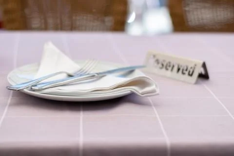 Table setting in a restaurant with reserved card. Stock Photos