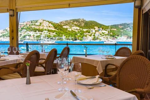 Table setting in restaurant with sea view of beautiful coast bay with yachts Stock Photos