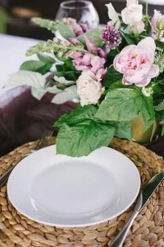 Table setting for a romantic dinner. Beautiful flowers in a vase on the table Stock Photos