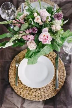 Table setting for a romantic dinner. Beautiful flowers in a vase on the table Stock Photos