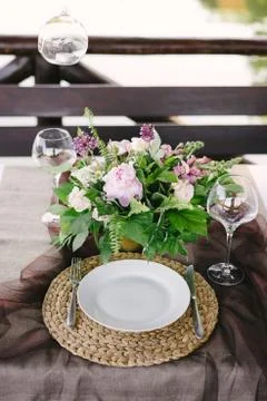 Table setting for a romantic dinner. Beautiful flowers in a vase on the table Stock Photos