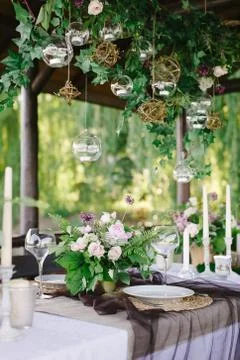 Table setting for a romantic dinner. Beautiful flowers in a vase on the table Stock Photos
