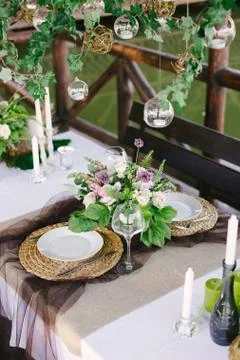 Table setting for a romantic dinner. Beautiful flowers in a vase on the table Stock Photos