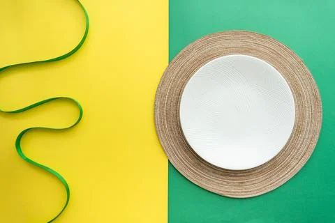 Table setting with table mat and dinnerware with green and yellow background. Stock Photos