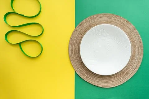Table setting with table mat and dinnerware with green and yellow background. Stock Photos