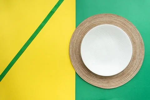 Table setting with table mat and dinnerware with green and yellow background. Stock Photos