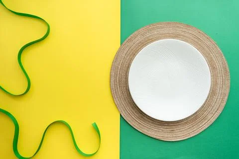 Table setting with table mat and dinnerware with green and yellow background. Stock Photos