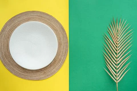 Table setting with table mat and dinnerware with green and yellow background. Stock Photos