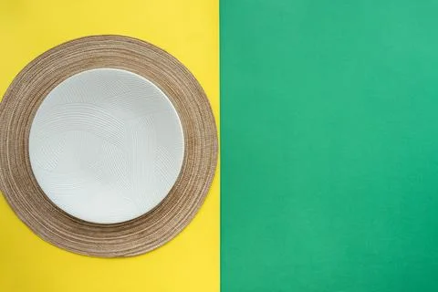 Table setting with table mat and dinnerware with green and yellow background. Stock Photos
