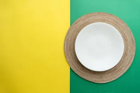 Table setting with table mat and dinnerware with green and yellow background. Stock Photos