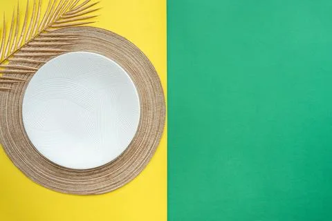 Table setting with table mat and dinnerware with green and yellow background. Stock-Fotos