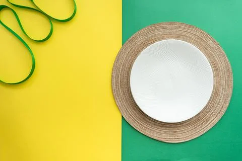 Table setting with table mat and dinnerware with green and yellow background. Stock Photos