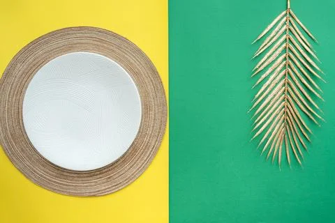 Table setting with table mat and dinnerware with green and yellow background. Stock Photos