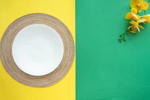 Table setting with table mat and dinnerware with green and yellow background. Stock Photos