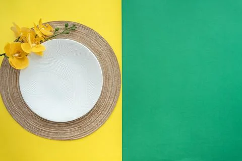 Table setting with table mat and dinnerware with green and yellow background. Stock Photos