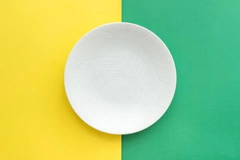 Table setting with table mat and dinnerware with green and yellow background. Stock-Fotos