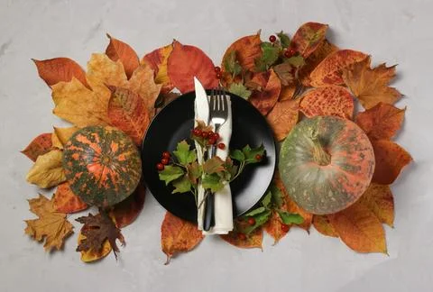 Table setting on Thanksgiving Day with pumpkin and colorful leaves with dar.. Stock Photos