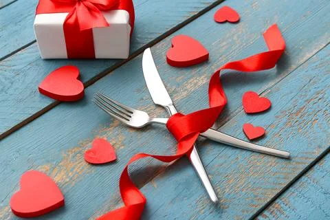 Table setting for Valentine's Day with cutlery, decorative hearts, ribbon and Stock Photos