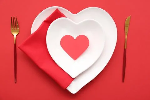 Table setting for Valentine's Day with paper heart on red background, closeup Stock Photos