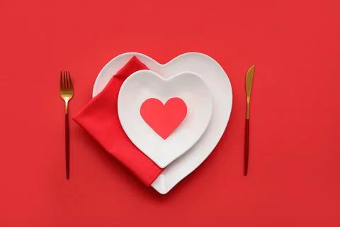 Table setting for Valentine's Day with paper heart on red background Stock Photos