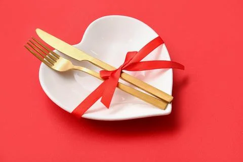 Table setting for Valentine's Day with ribbon on red background, closeup Stock Photos