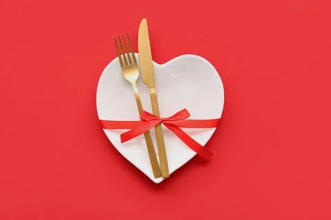 Table setting for Valentine's Day with ribbon on red background Stock Photos