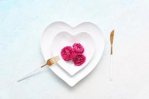 Table setting for Valentine's Day with rose flowers on blue grunge background Stock Photos