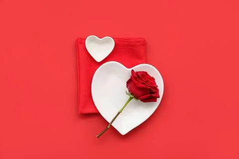 Table setting for Valentine's Day with rose flower on red background Stock Photos