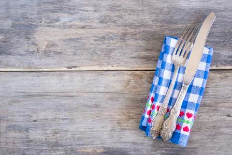 Table setting with vintage fork and knife on blue and white checkered napkin  Stock Photos