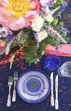 Table setting in vintage style is decorated with flowers in pink and blue colors Foto stock