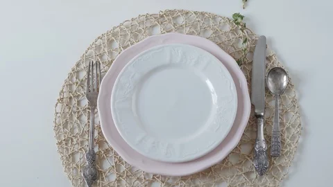 Table setting with white dishes on white background. the woman beautifully folds Stock Footage 108328077