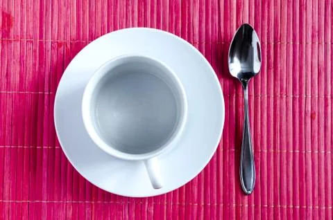 Table setting white plate mug and spoon on a red background Stock Photos
