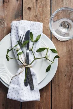Table setting with white plates and mistletoe. Stock Photos