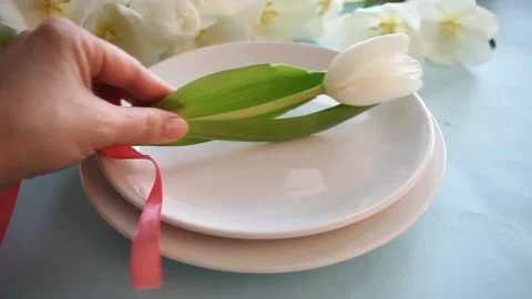 Table setting with white tulip on the plate. Spring and Easter concept.Human Stock Footage 150803547