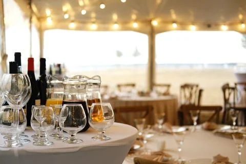 Table setting with wine bottles, glasses, and a pitcher on white tablecloth in a Stock Photos