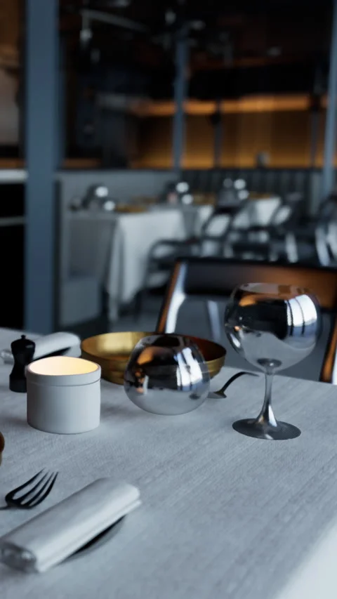Table setup in a restaurant with silver items and a candle for dinner Stock Footage 337940280