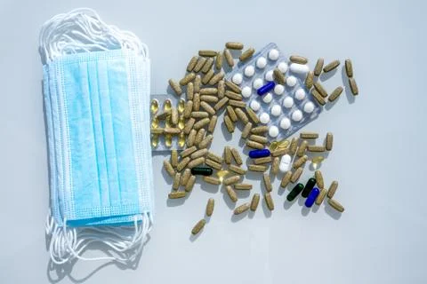 A table with several surgical masks. Assorted pharmaceutical medicine pills Stock Photos