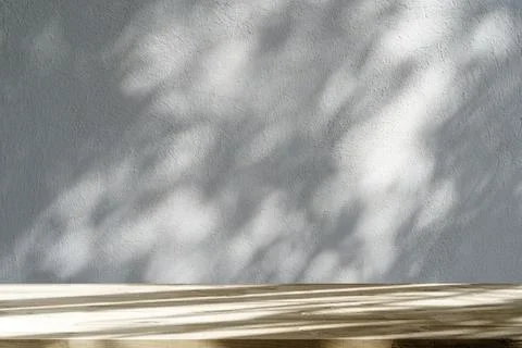 Table shadow background. Wooden table and white empty wall with plant shadows. Stock Photos