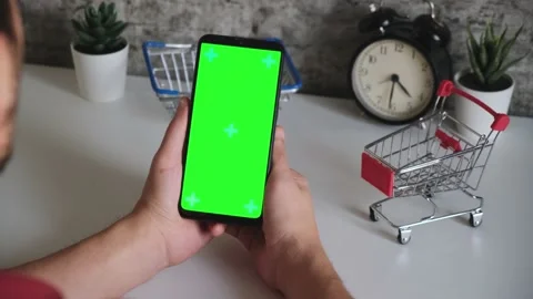 Table with shopping baskets close-up mobile phone in hands with green screen Stock Footage 144802010
