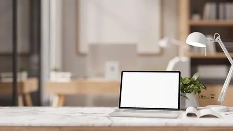The table showcases a white-screen laptop computer in a contemporary office. Stock Illustration