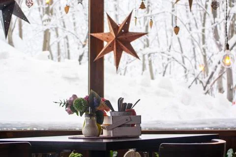 A table with a small bouquet in a cafe by the window. winter Stock Photos