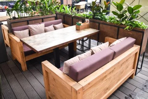 Table with sofas for visitors in the cafe, under the open sky. summer cafe. Stock Photos