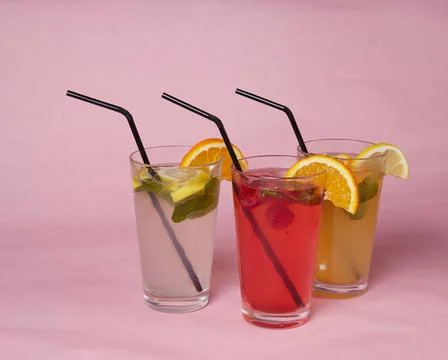 On the table, soft drinks, various cocktails, a glass with a straw and a slice Stock Photos
