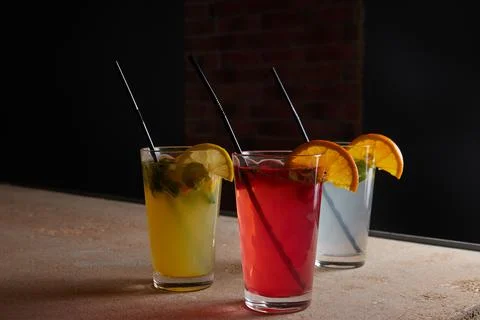 On the table, soft drinks, various cocktails, a glass with a straw and a slice Stock Photos
