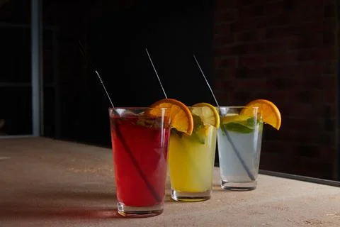 On the table, soft drinks, various cocktails, a glass with a straw and a slice Stock Photos